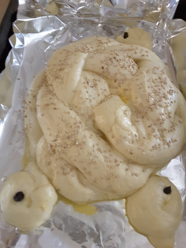unbaked round challah for Rosh Hashanah with three "doves" made from dough scraps and raisin eyes