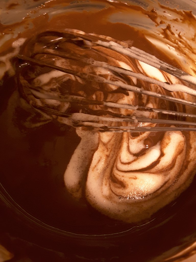 Folding beaten egg whites into the microwaved chocolate base for a lightened-up chocolate mousse.