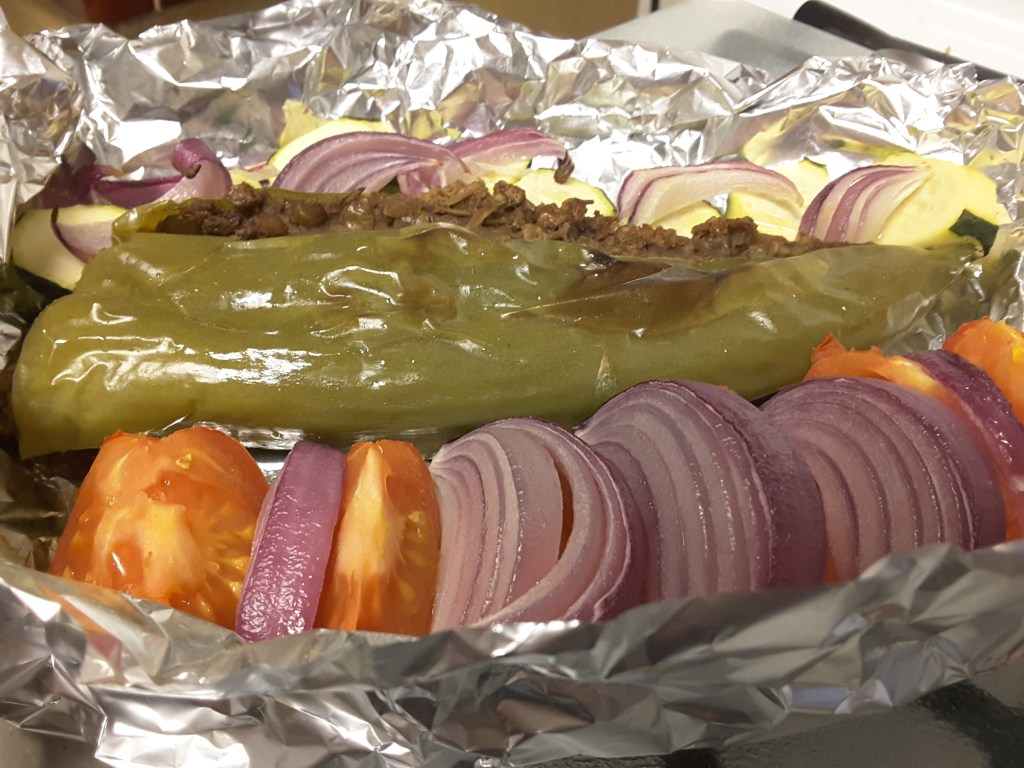 Lentil-stuffed Anaheim chile with zucchini, tomatoes and red onion in a Persian-style vegetarian platter grilled in the toaster oven.